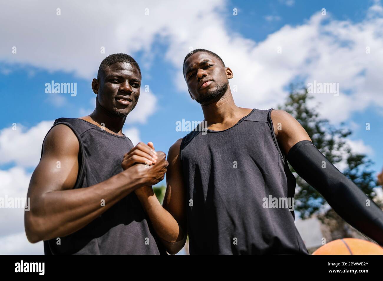 Giocatori di basket che si scuotono sul campo da pallacanestro all'aperto Foto Stock