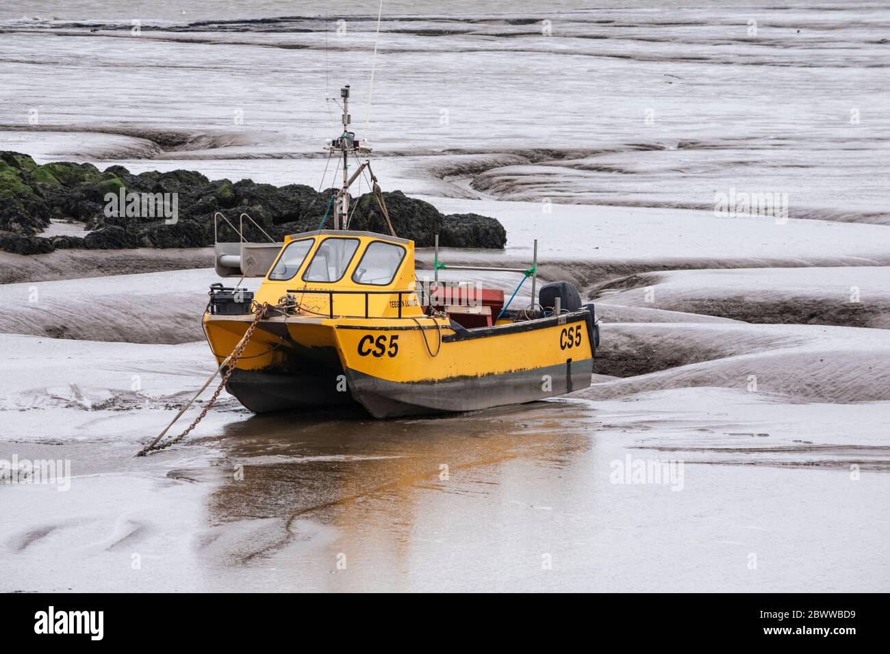 Piccola barca da pesca gialla aggirata a Morecambe, Lancashire Foto Stock