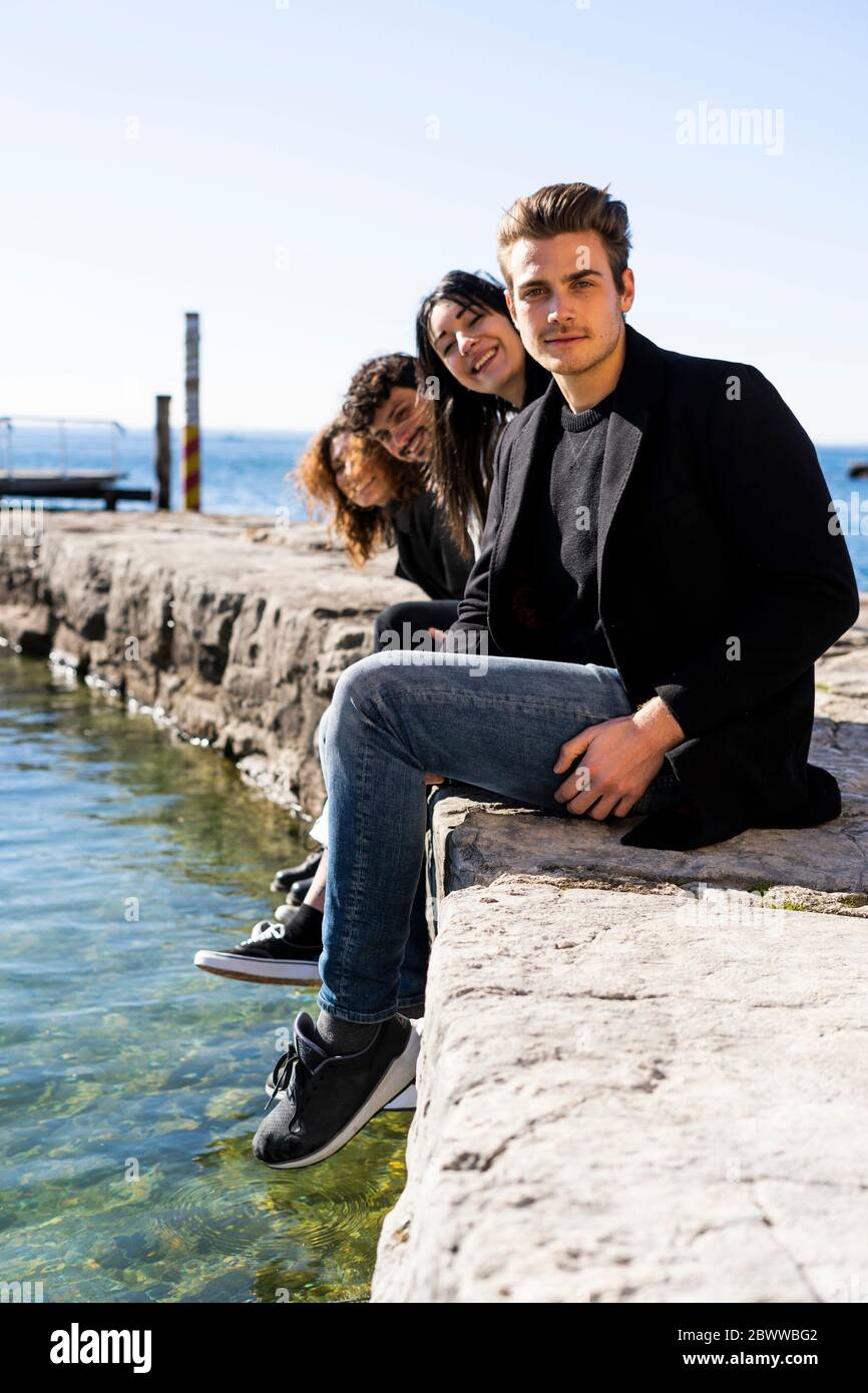 Ritratto di quattro amici seduti sul Lago di Garda Foto Stock