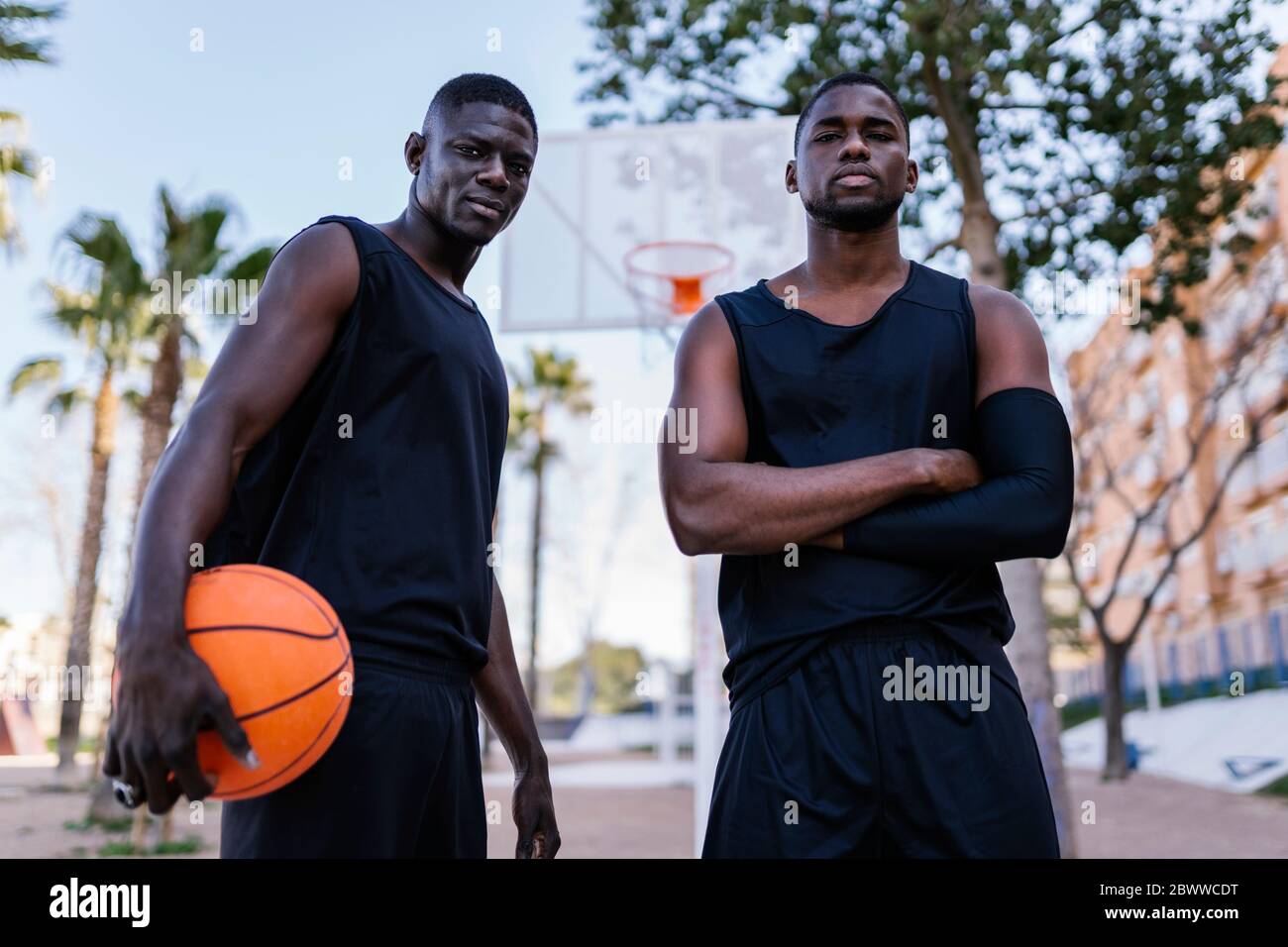 Giovani uomini con basket sul campo da pallacanestro Foto Stock