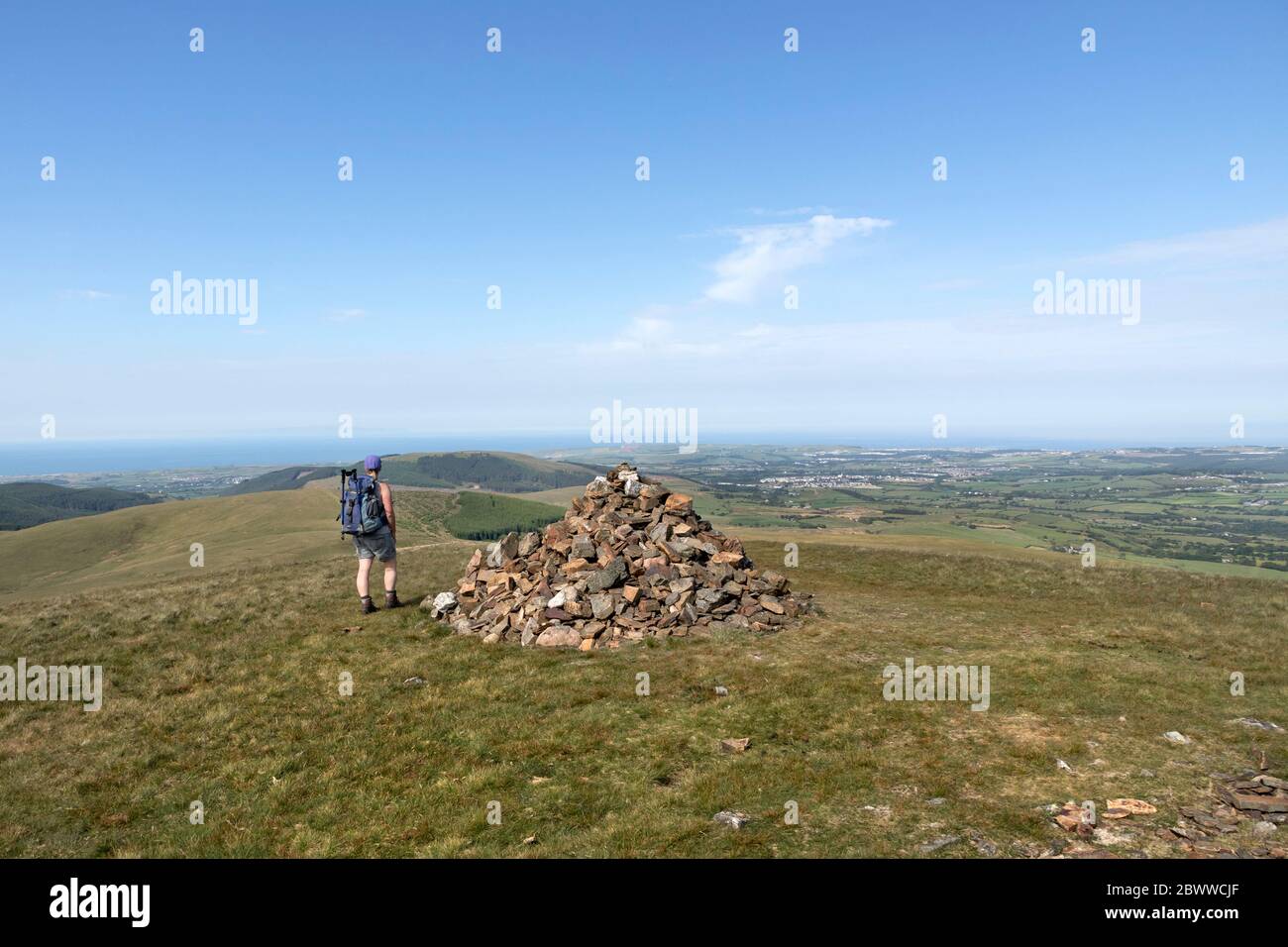 Walker godendo la vista ovest dalla cima di Grike verso la costa in un giorno caldo estivo, Lake District, Cumbria, Regno Unito Foto Stock