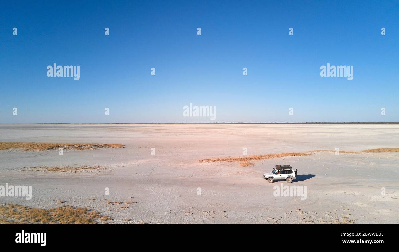 Botswana, veduta aerea di un'auto 4x4 che attraversa la panna di Makgadikgadi Foto Stock