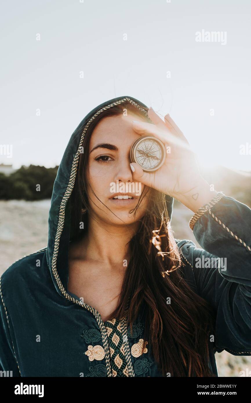 Ritratto di giovane donna che ricopre l'occhio con bussola, Marocco Foto Stock