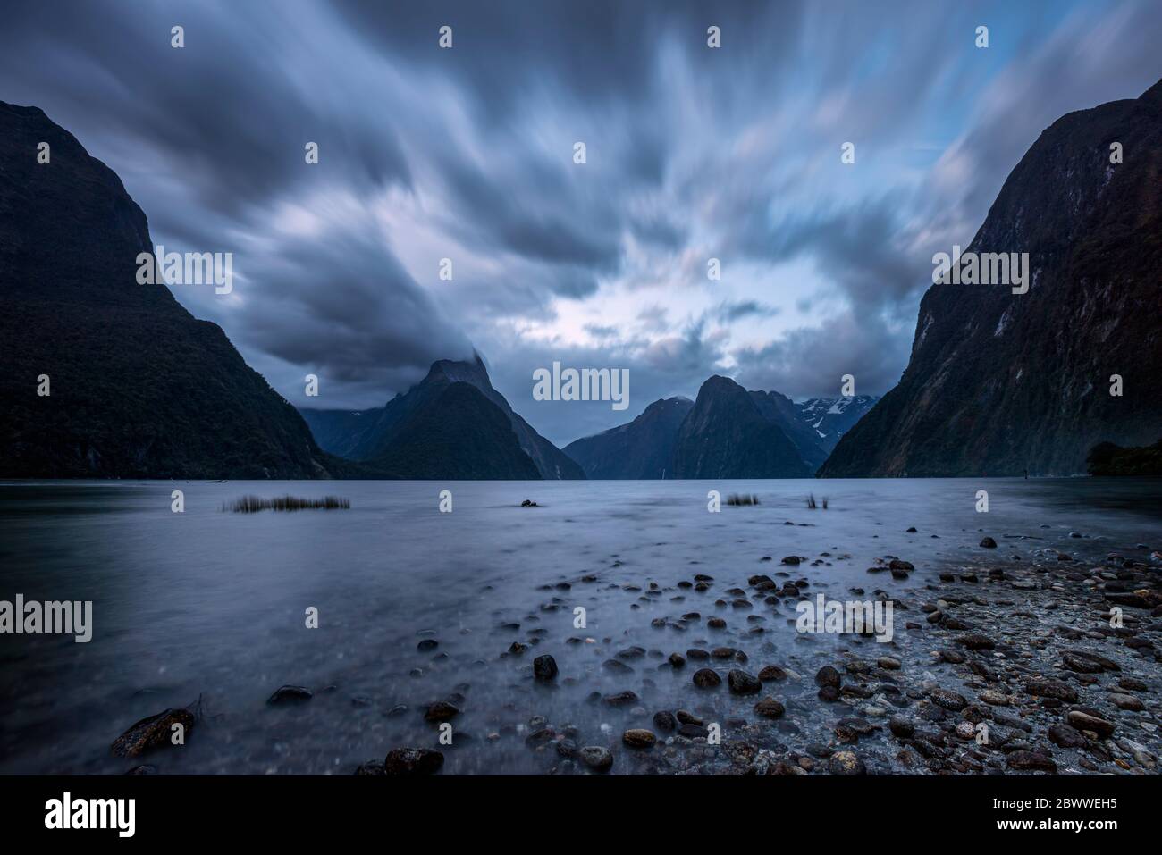 Nuova Zelanda, Southland, lunga esposizione di nuvole tempesta sulla costa panoramica di Milford Sound Foto Stock