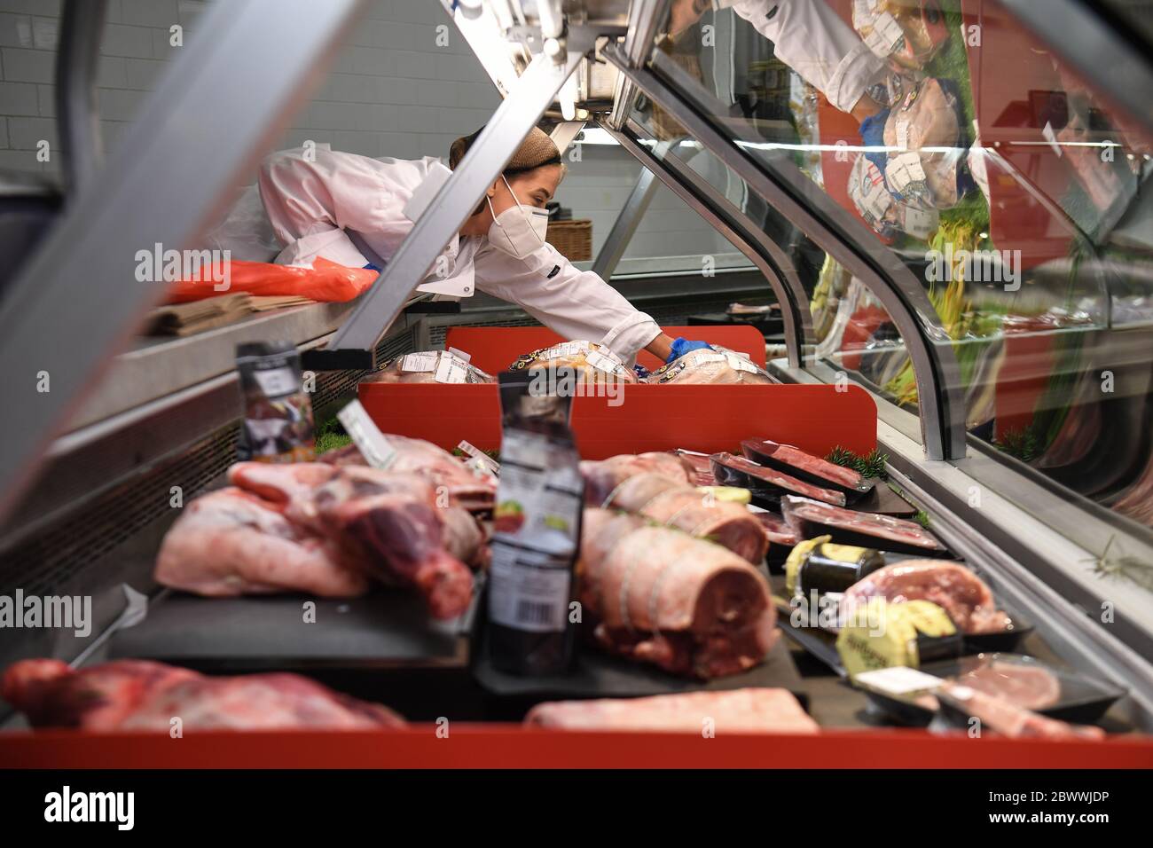 Un membro dello staff che indossa una maschera ripone il banco di carne nella foodhall di Selfridges, Londra, dopo l'introduzione di misure per portare l'Inghilterra fuori dal blocco. Foto Stock