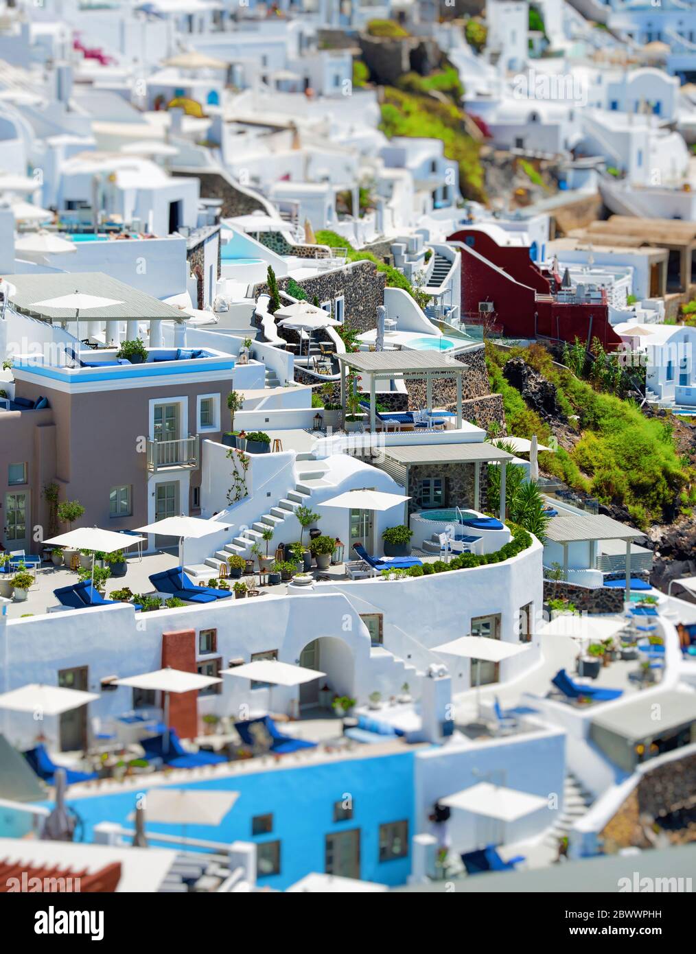 Vista dall'alto delle ville di Santorini. Panorama di piccole case con piscina d'acqua blu su terrazza bianca, sfondo sfocato Foto Stock Vista dall'alto delle ville di Santorini. Panorama di piccole case con piscina d'acqua blu su terrazza bianca, sfondo sfocato Foto Stock