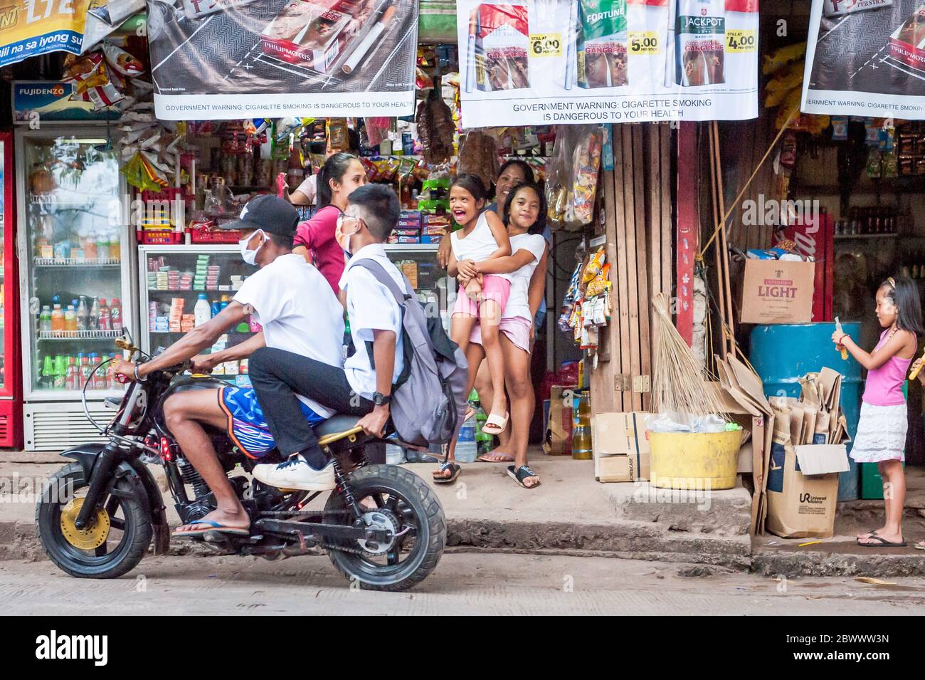 I bambini filippini giocano per la macchina fotografica all'esterno di un minimarket locale sull'isola di Coron, Palawan, nelle Filippine. Foto Stock