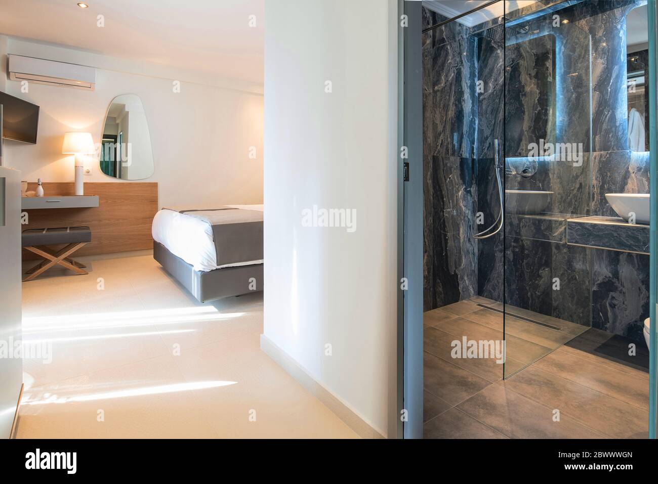Interni moderni di colore grigio con camera da letto in legno e bagno in marmo in camera d'appartamento dell'hotel con spazio per la copia a parete vuota Foto Stock