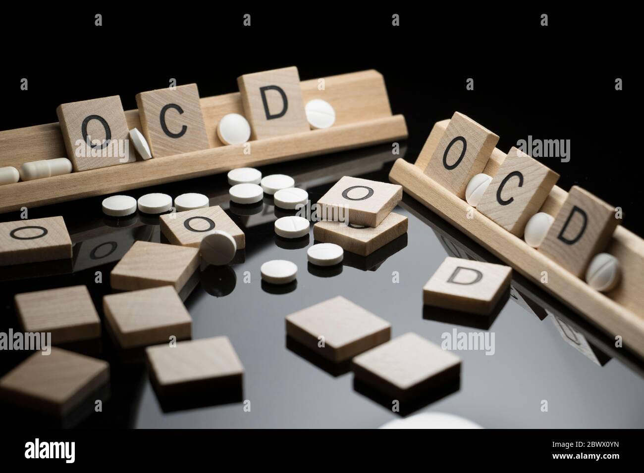 Concetto OCD scritto in testo con farmaci farmaceutici su una tavola nera. Disturbo ossessivo compulsivo e problemi di salute comportamentale. Foto Stock