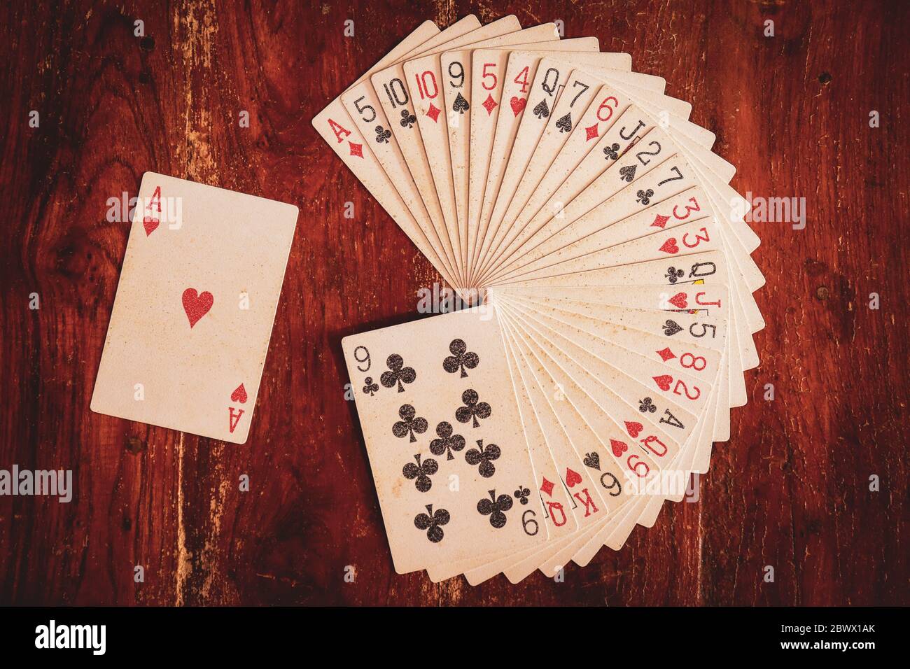 Mazzo di carte da gioco disposte in stack circolare o disegno o modello con asso di cuori da parte su uno sfondo di legno per l'esecuzione di illusione o magia Foto Stock