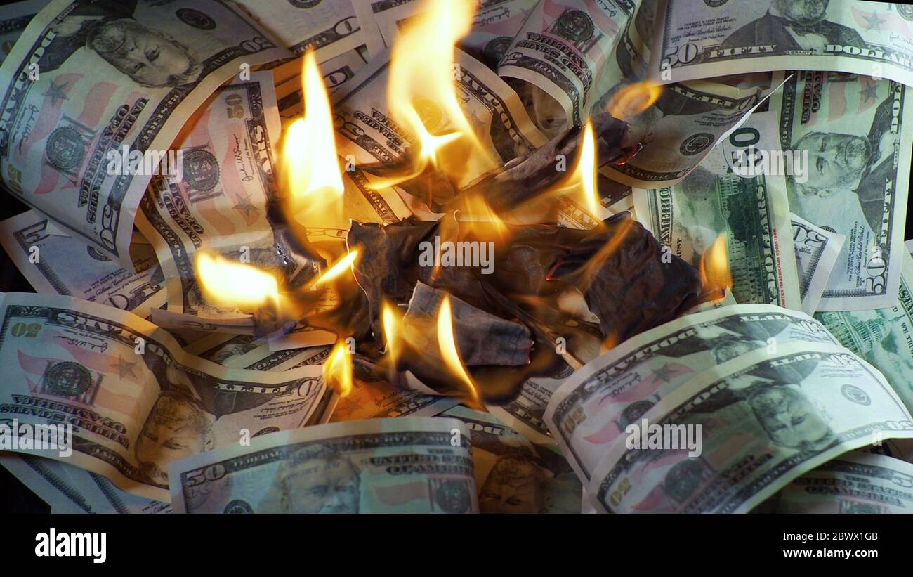 Un sacco di dollari nel fuoco, la crisi finanziaria globale e l'inflazione, il concetto. Lotti delle fatture del dollaro brucianti, bruciando e fumando, sparare naturale. Foto Stock