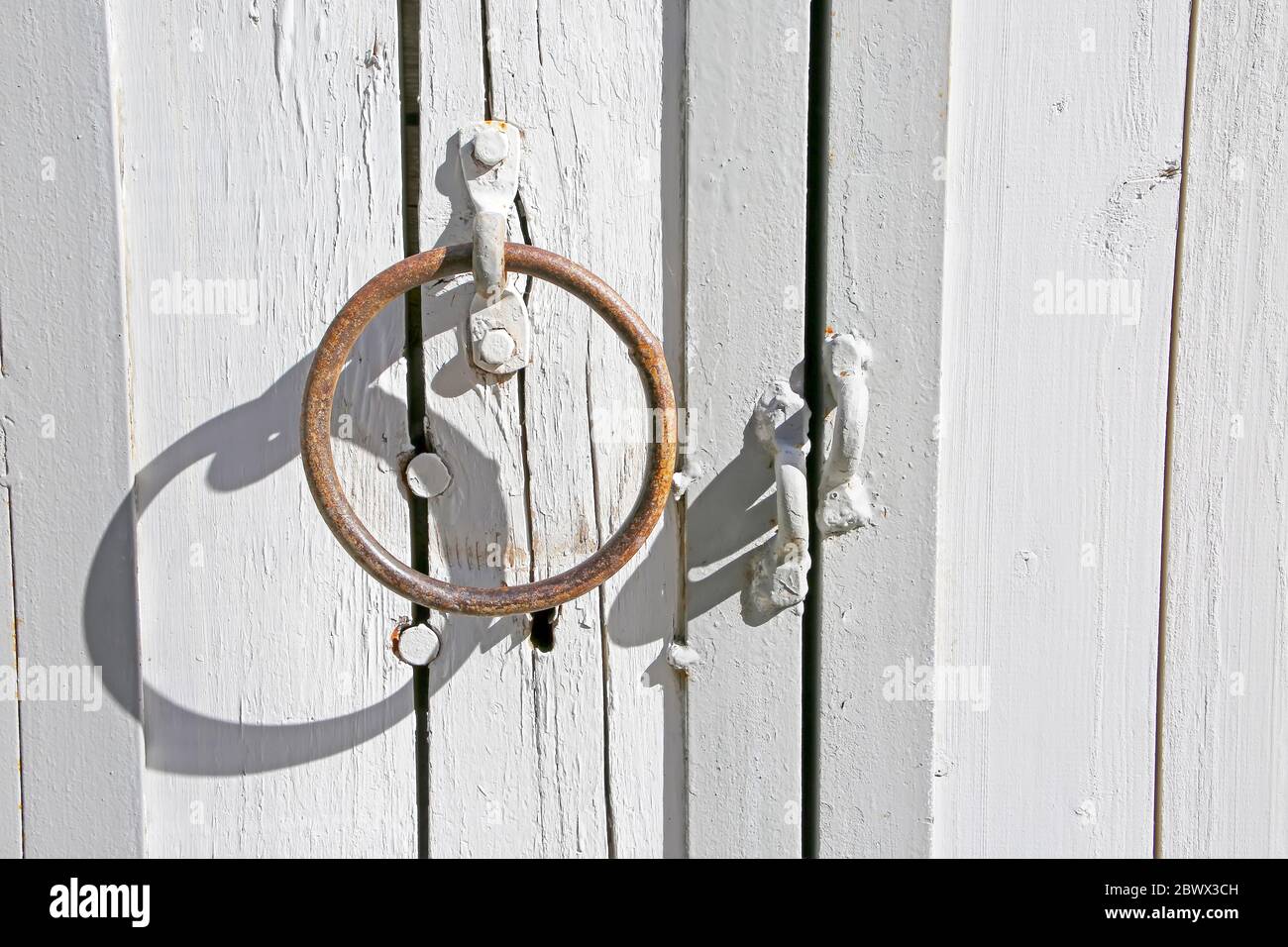 Maniglia tradizionale su una porta di legno bianco nella città vecchia, Tallinn, Estonia. Foto Stock