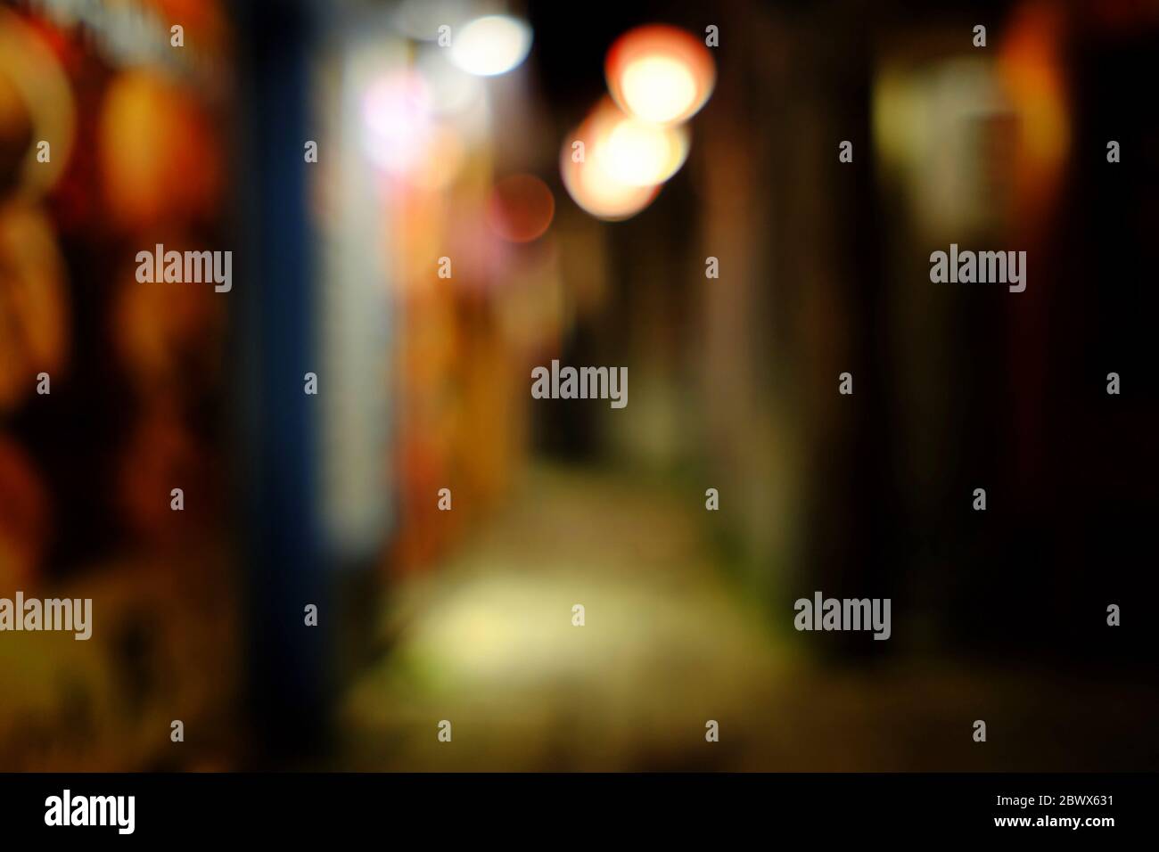 Vicolo desolato scuro sfocato con sfondo bokeh. Foto Stock