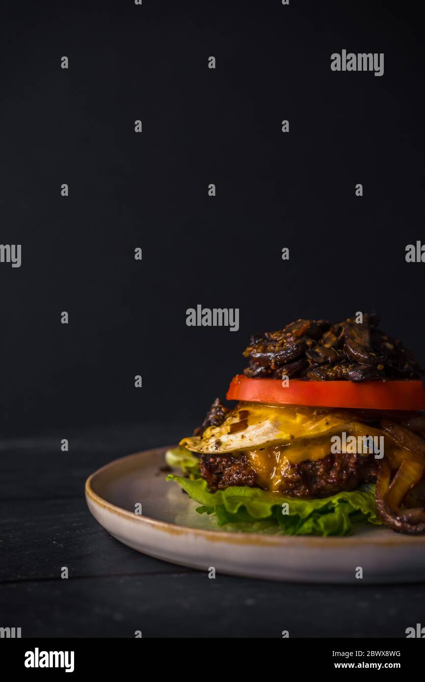 Bunch Burger senza glutine di manzo cipolle funghi cibo scuro uovo pomodoro Foto Stock