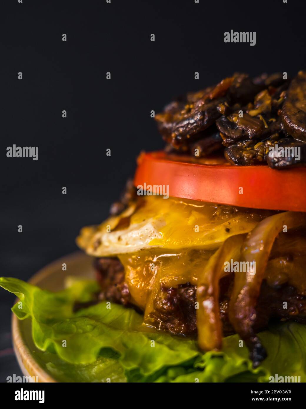 Bunch Burger senza glutine di manzo cipolle funghi cibo scuro uovo pomodoro Foto Stock