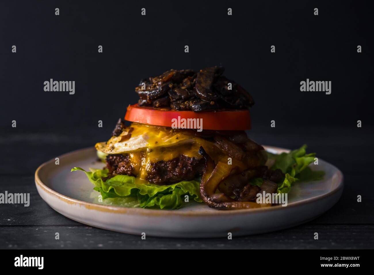 Bunch Burger senza glutine di manzo cipolle funghi cibo scuro uovo pomodoro Foto Stock
