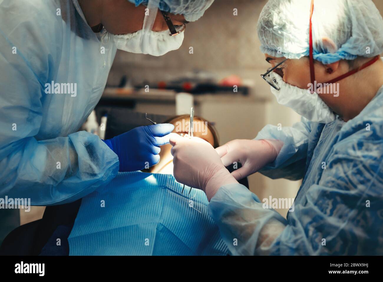Dentista e assistente trattano i denti di piccola ragazza Foto Stock