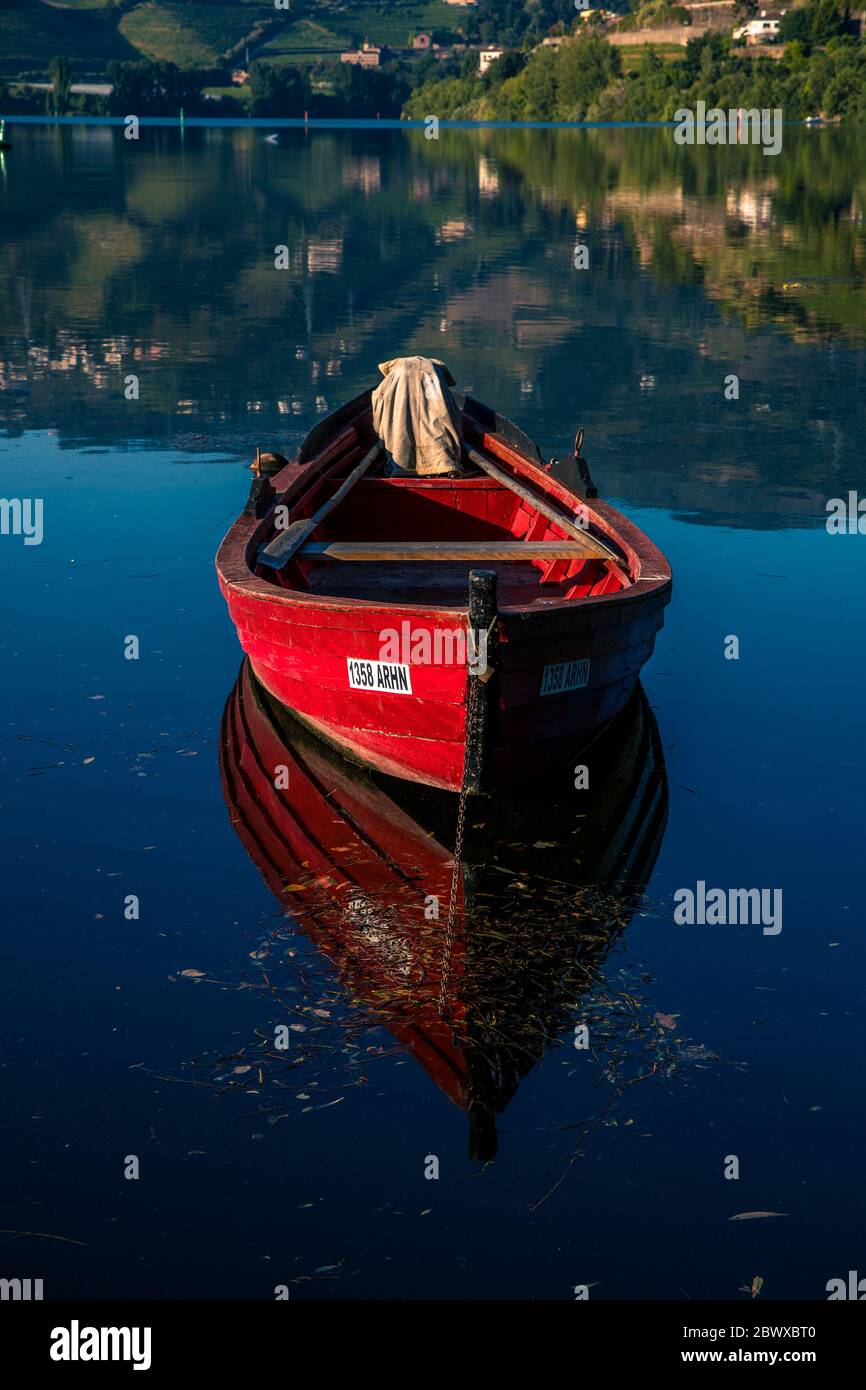 Vista con barca da pesca tradizionale rossa con riflessi sul fiume Douro Portogallo settentrionale Foto Stock