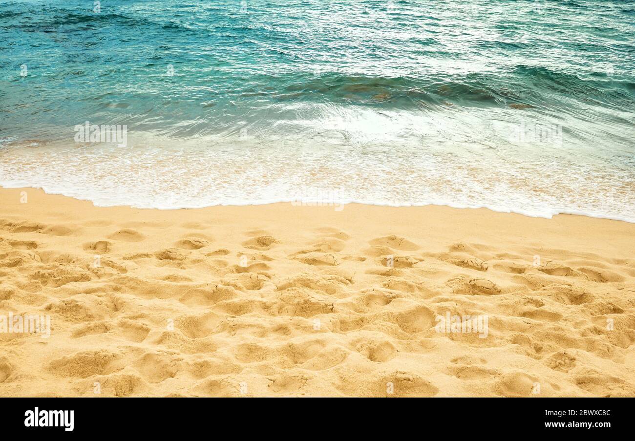 Spiaggia di sabbia e mare bordo d'acqua, sfondo estivo. Foto Stock