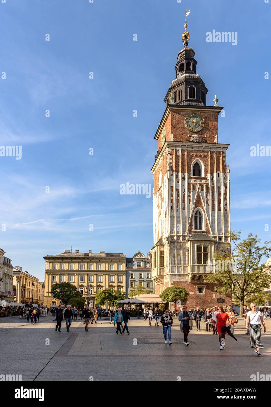 Torre del Palazzo Comunale in piedi sopra i turisti sulla piazza principale della città vecchia di Cracovia in Polonia in una calda giornata d'autunno Foto Stock