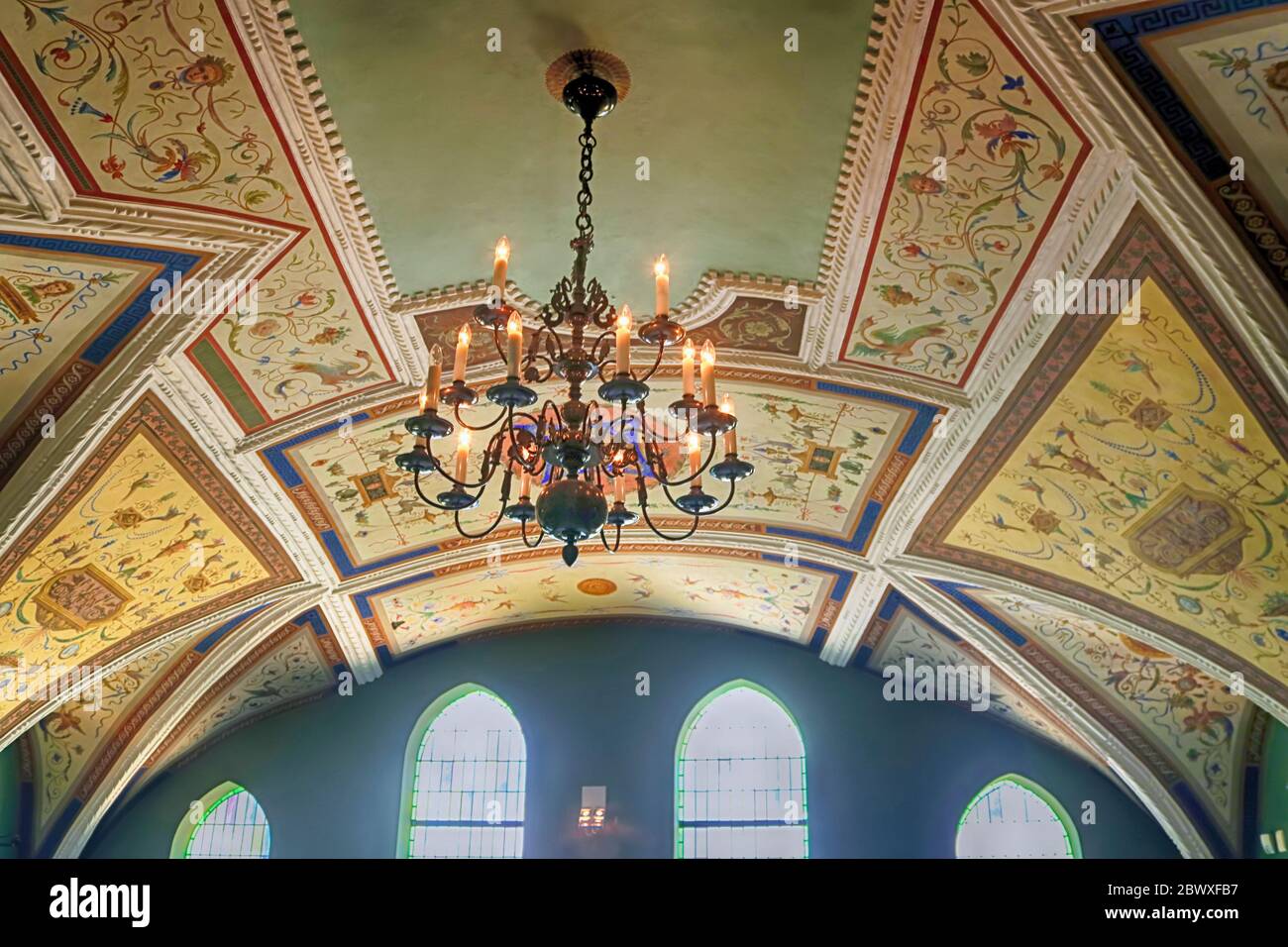 BRATISLAVA, SLOVACCHIA - 03 SETTEMBRE 2019: Lampadario e soffitto dipinto della stanza nel municipio. Finestre a mosaico Foto Stock