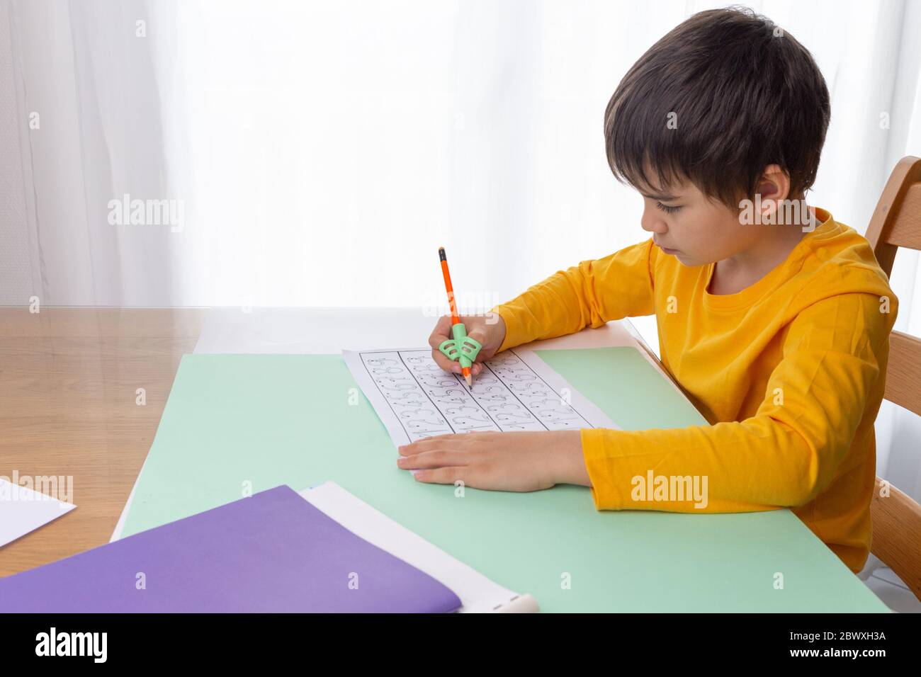 lavoro di scrittura del ragazzo, strumento di correzione di handwriting, addestramento di scrittura di preschool, istruzione dei bambini a casa Foto Stock
