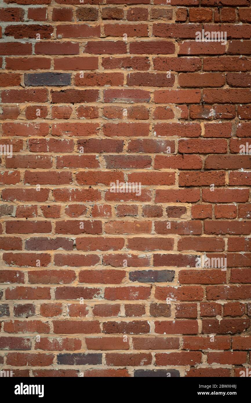 Sfondo alto muro di mattoni, mattone stagionato vintage parzialmente reinspect, spazio creativo copia, aspetto verticale Foto Stock
