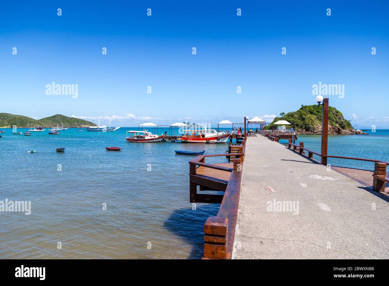 Buzios Marina in una soleggiata mattina d'estate. Alcune persone che aspettano al molo per salire a bordo. ARMAÇÃO DOS BUZIOS, STATO DI RIO DE JANEIRO, BRASILE Foto Stock