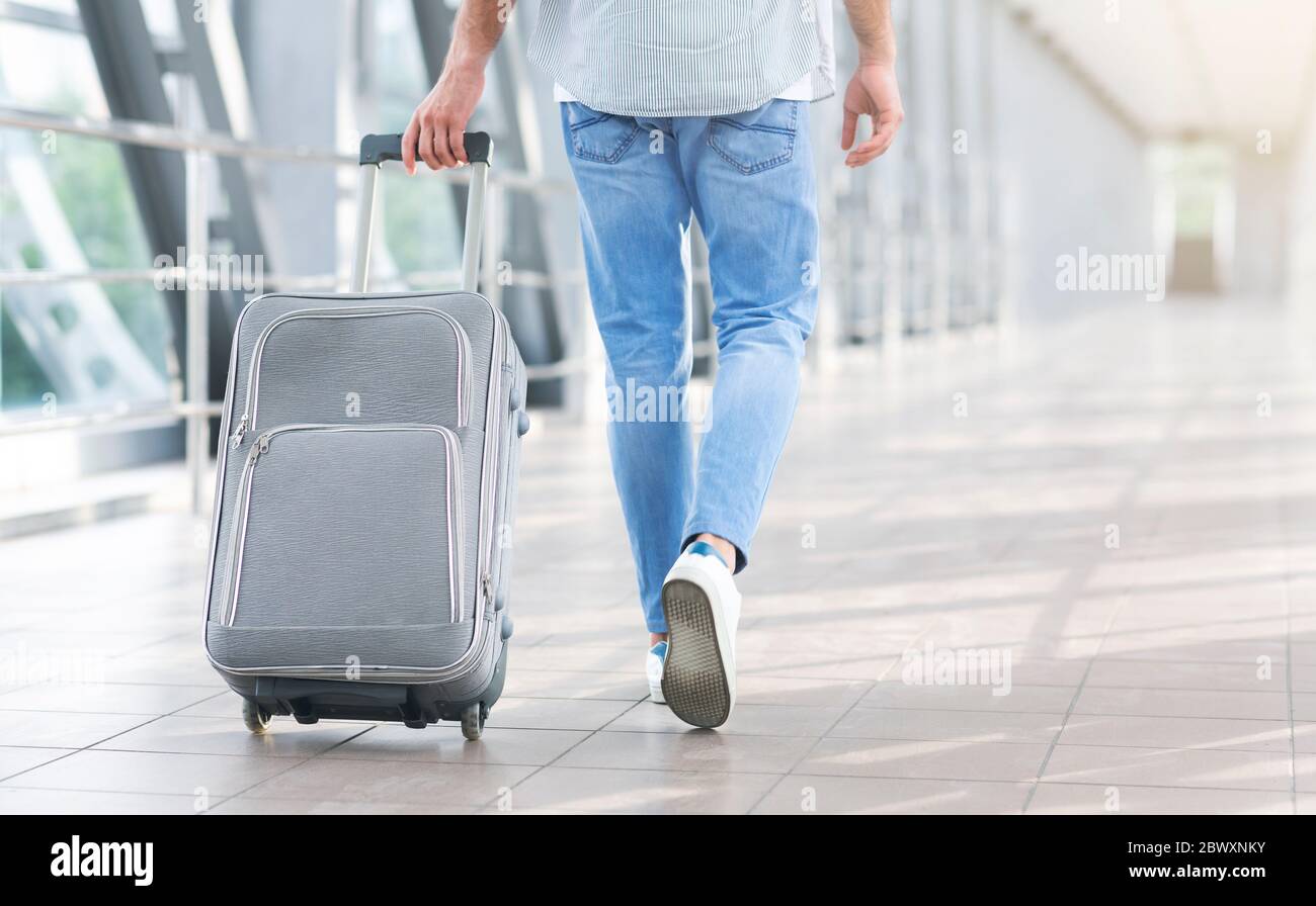 Unriconoscable Man Walking con valigia in aeroporto, andando al cancello d' imbarco Foto stock - Alamy