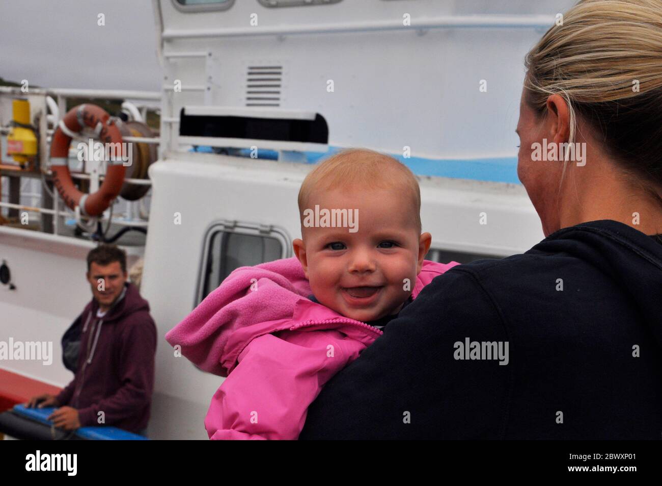 Un bambino piccolo che gode un viaggio su una delle barche inter Island delle isole di Scilly, Cornovaglia; Regno Unito Foto Stock