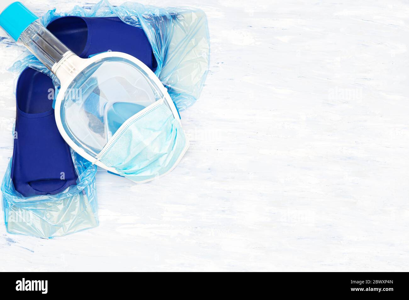 Vacanza estiva in mezzo al concetto di coronavirus. Vacanze al mare annullate e piani di viaggio per l'estate 2020. Maschera da snorkeling con una maschera monouso e un paio di Foto Stock