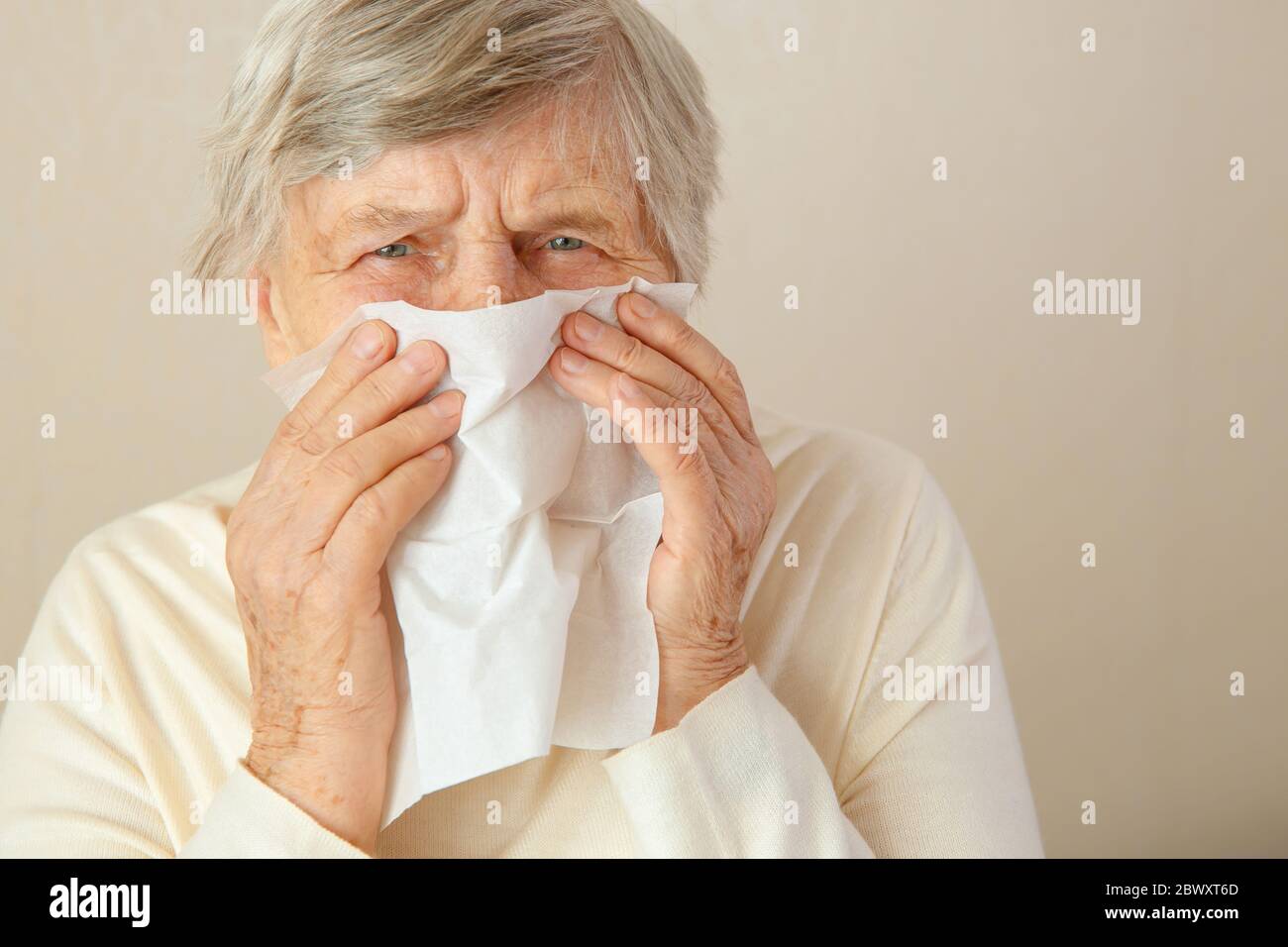 Naso che corre. Donna anziana che passa tutto il giorno mentre ha il naso che corre. Una donna anziana ha un naso chiuso o naso che cola ed è in febbre. Foto Stock