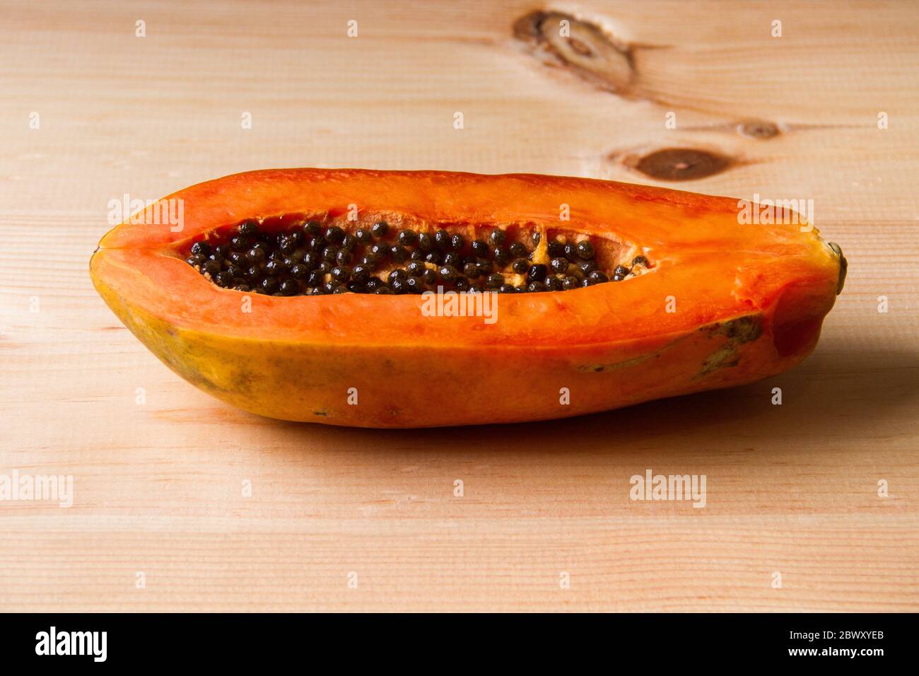 Frutta matura di papaya metà su tavola di legno Foto Stock