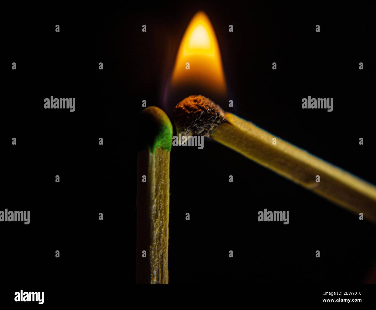 Un abbinamento di legno con una fiamma che illumina un abbinamento di legno Su sfondo nero Foto Stock