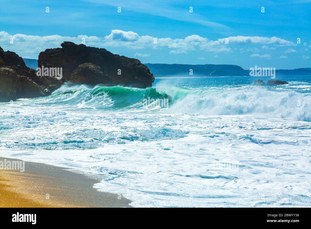 Grandi onde si schiantano nelle rocce della spiaggia del nord nella città di Nazare, Portogallo Foto Stock