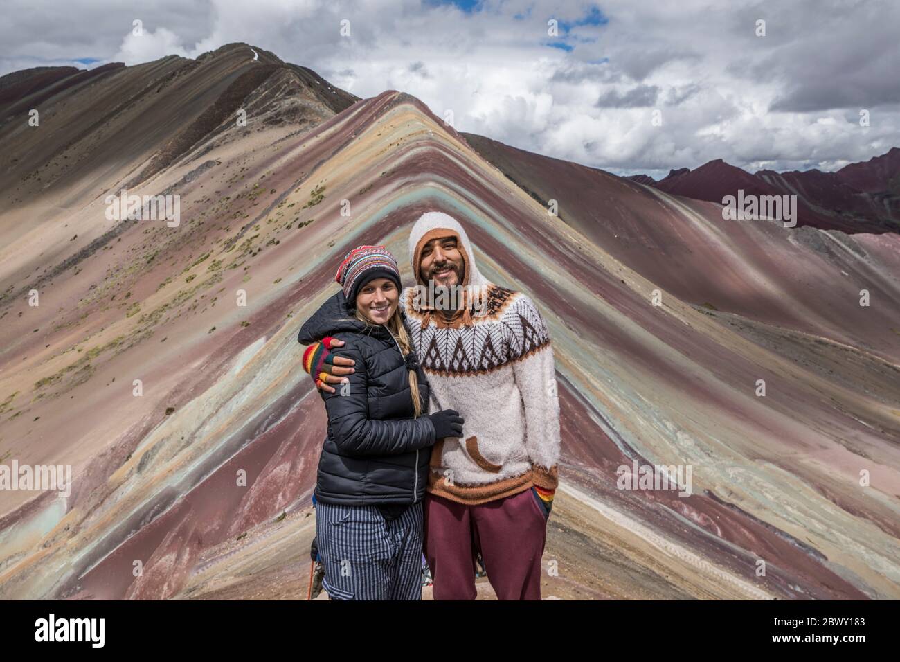 Bella coppia felice in bel paesaggio nella montagna arcobaleno in Perù con tutti i colori della montagna sullo sfondo. Foto Stock