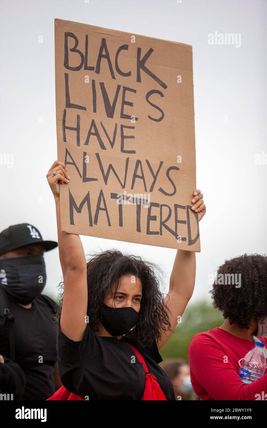 Giovane donna, indossando una maschera facciale, tenendo un segno che dice 'le vite nere hanno sempre contato', durante la protesta di Black Lives Matter UK. Londra Foto Stock