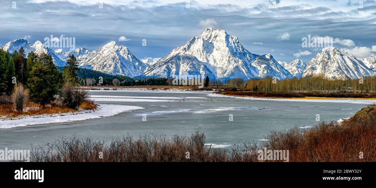 Neve coperta Monte Moran e le montagne Teton torre sopra le acque Icy di Oxbow Bend in una fredda mattina invernale nel Parco Nazionale di Grand Teton Foto Stock