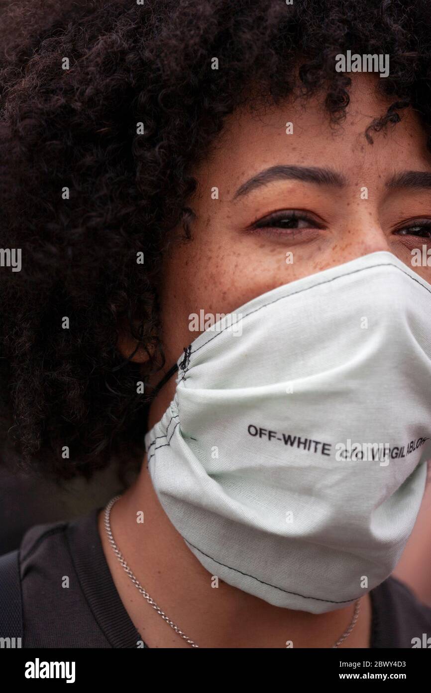 Ritratto di una giovane donna che indossa una maschera protettiva, durante la marcia di protesta del Regno Unito Black Lives Matter. Londra, Inghilterra, Regno Unito Foto Stock