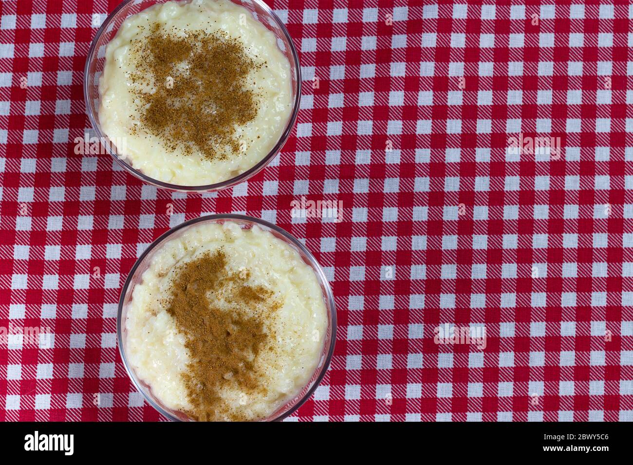 Due ciotole di riso dolce o budino di riso con glassa di cannella in polvere. Foto Stock