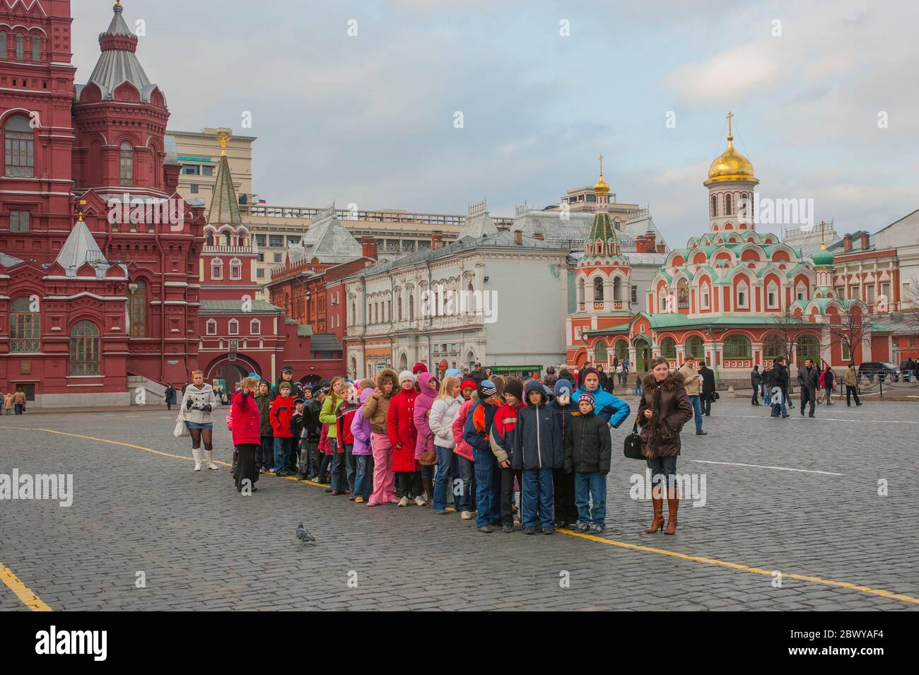 Bambini della scuola in Piazza Rossa (Patrimonio dell'Umanità dell'UNESCO) a Mosca, Russia, con la Cattedrale di Kazan sullo sfondo. Foto Stock