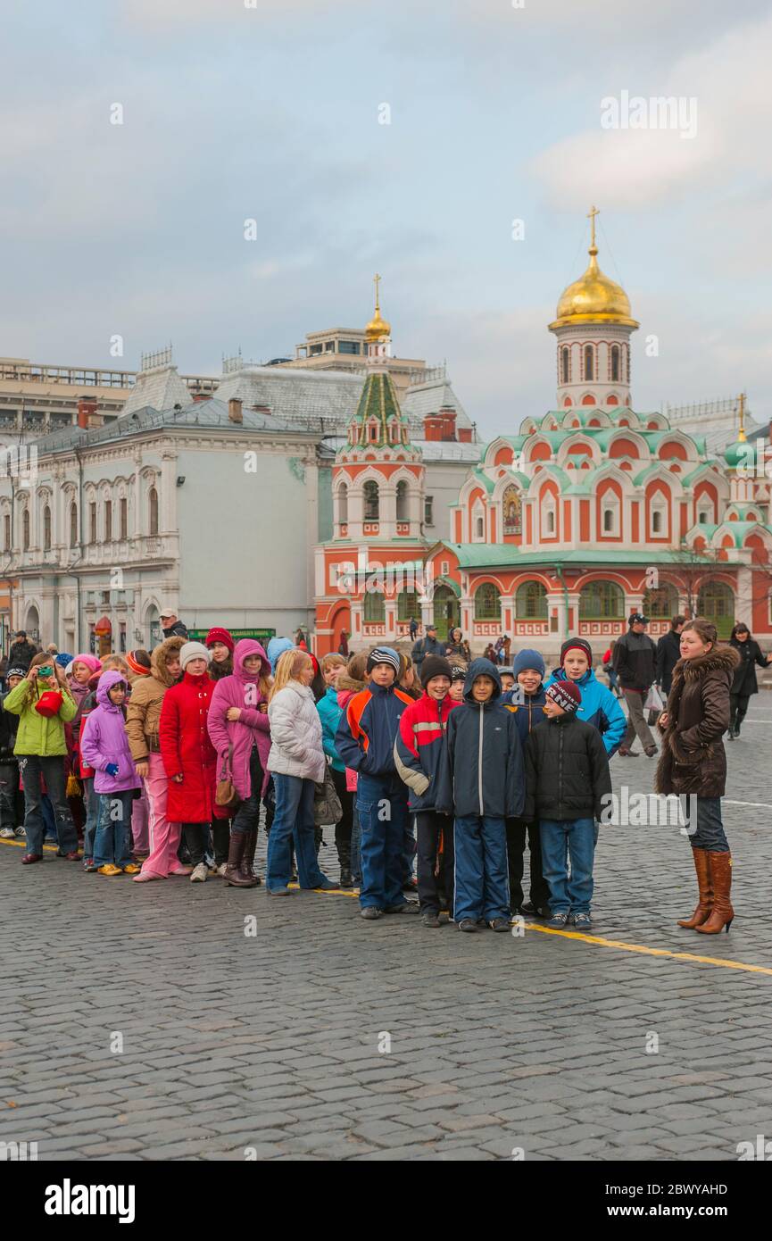 Bambini della scuola in Piazza Rossa (Patrimonio dell'Umanità dell'UNESCO) a Mosca, Russia, con la Cattedrale di Kazan sullo sfondo. Foto Stock