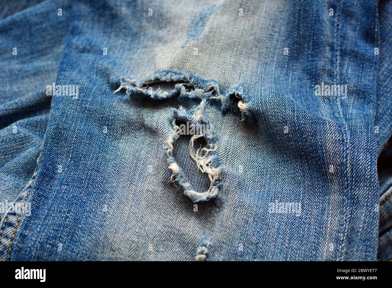 Jeans strappati, attrezzatura e fili per la riparazione di vestiti.  Tessuto, sfondo denim. Moda, sartoria domestica, concetto di riparazione  dell'abbigliamento Foto stock - Alamy
