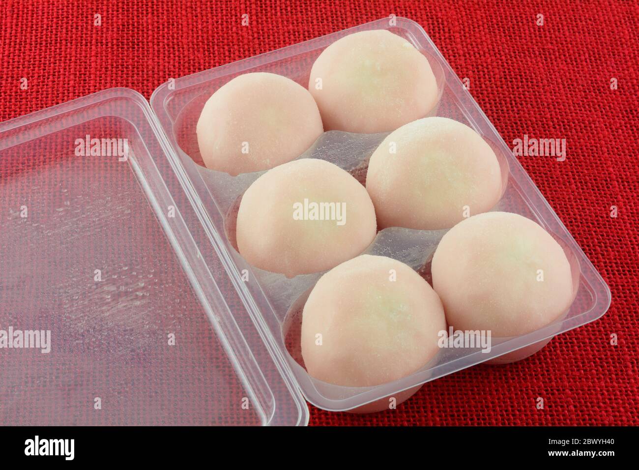 Gelato alla fragola congelato mochi in confezione di plastica su tovaglia Foto Stock