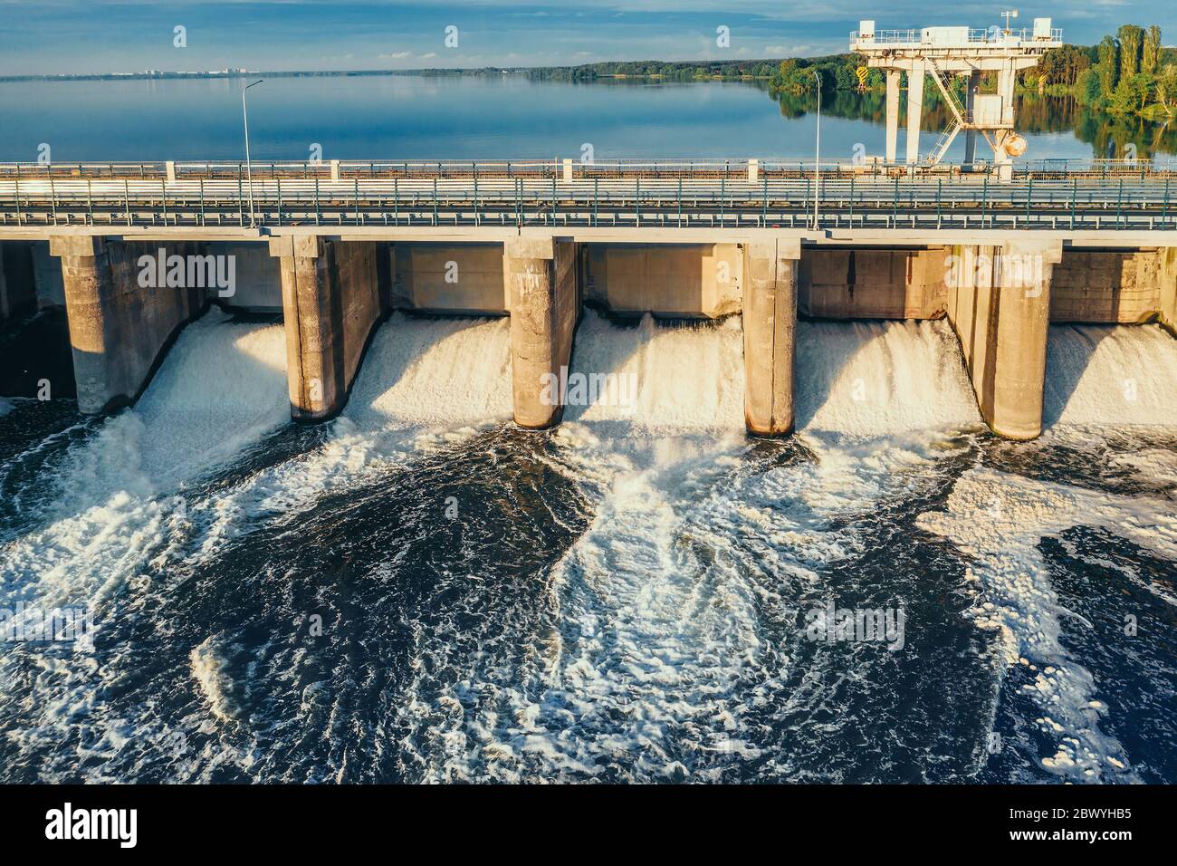 Diga idroelettrica o centrale idroelettrica al serbatoio dell'acqua, vista aerea dal drone. Scarico dell'acqua attraverso il cancello, hydropower. Foto Stock