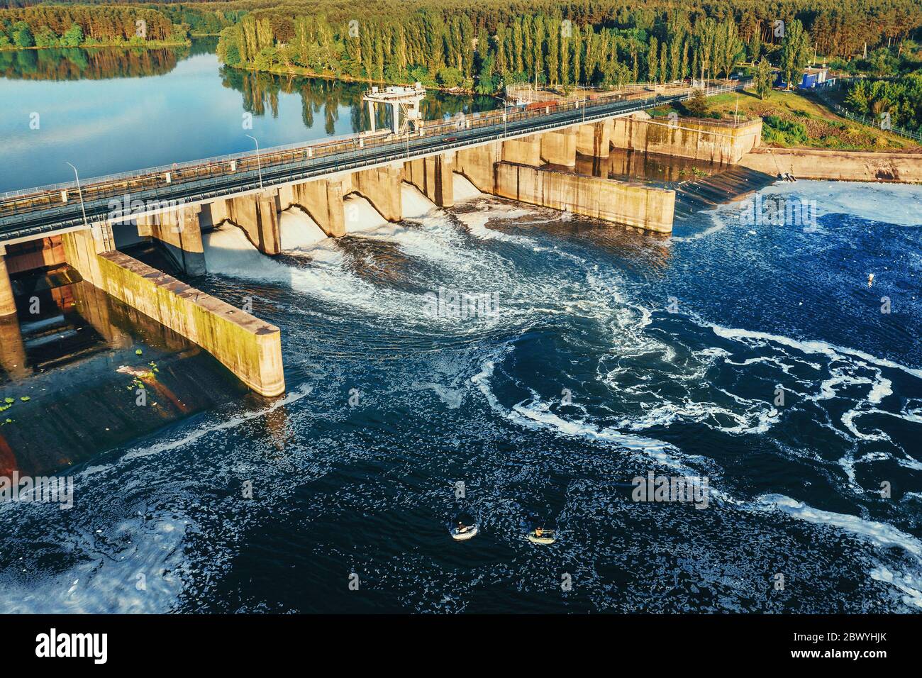 Diga idroelettrica o centrale idroelettrica al serbatoio dell'acqua, vista aerea dal drone. Scarico dell'acqua attraverso il cancello, hydropower. Foto Stock
