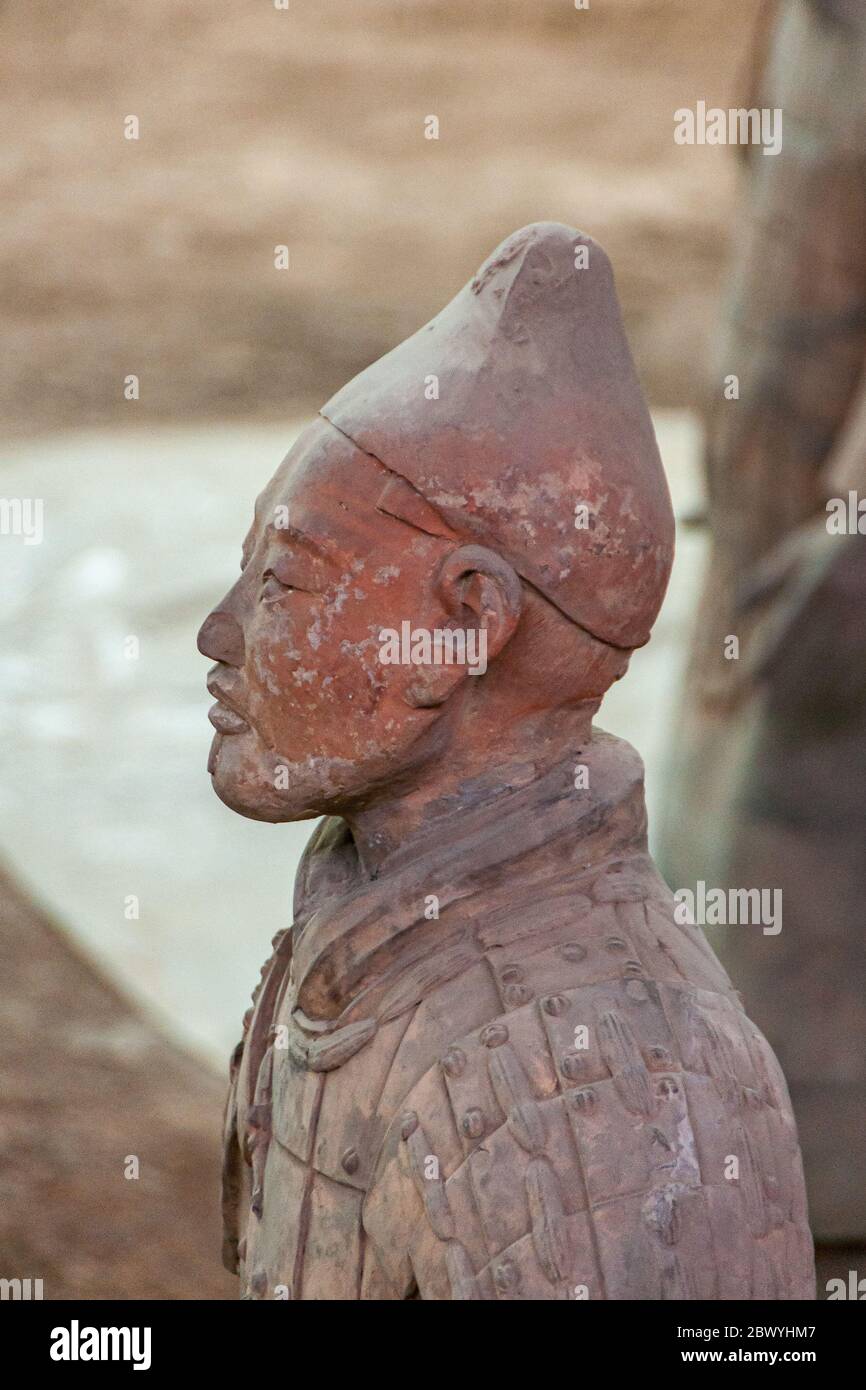 Xian, Cina - 1 maggio 2010: Museo e sala dell'Esercito di terracotta. Primo piano sul lato della faccia su scultura grigio-rossastra del soldato durante lo scavo. Foto Stock