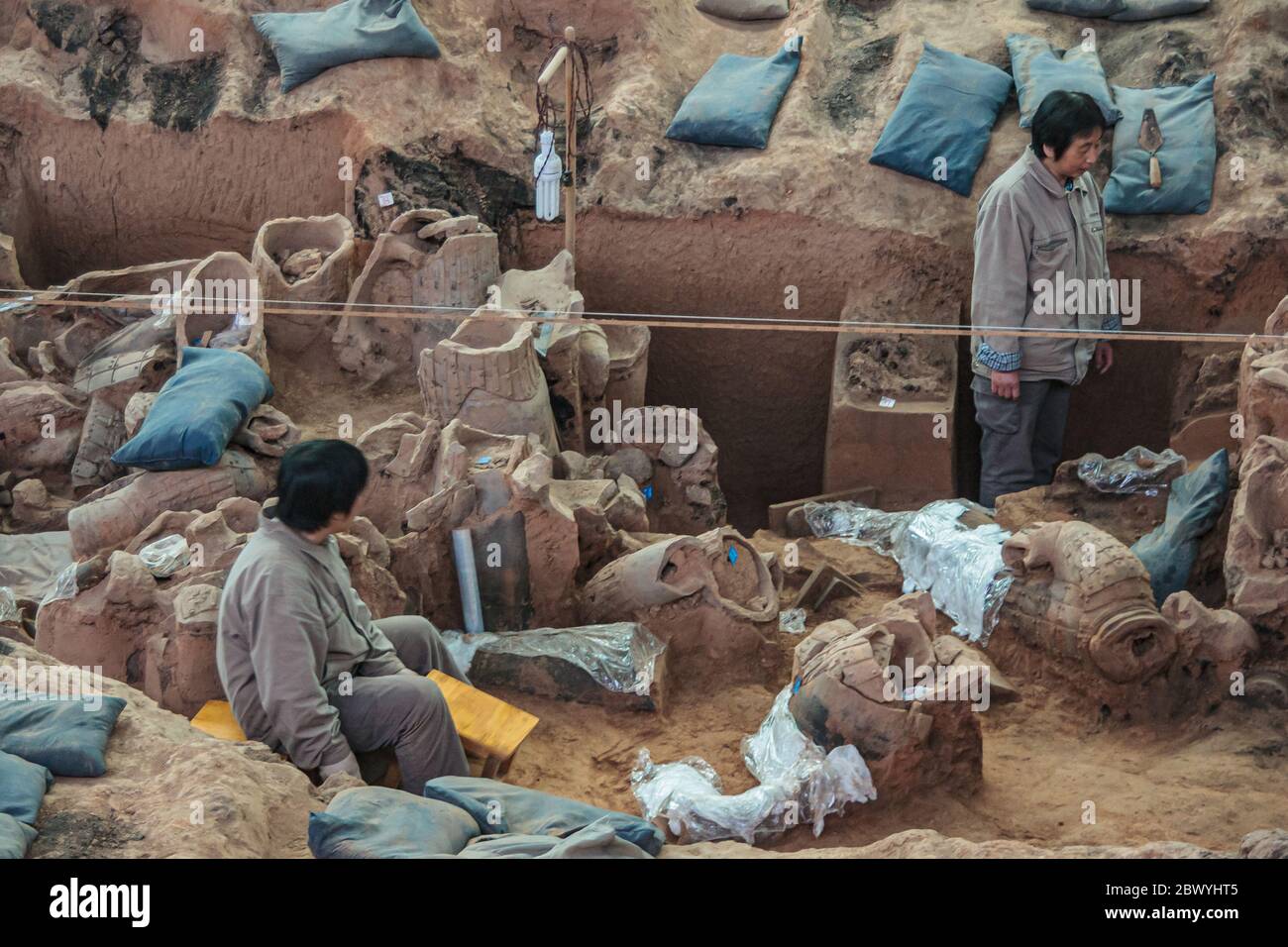 Xian, Cina - 1 maggio 2010: Museo e sala dell'Esercito di terracotta. 2 ricercatori che lavorano nella sporcizia, trovando nuove sculture, allo scavo. Foto Stock