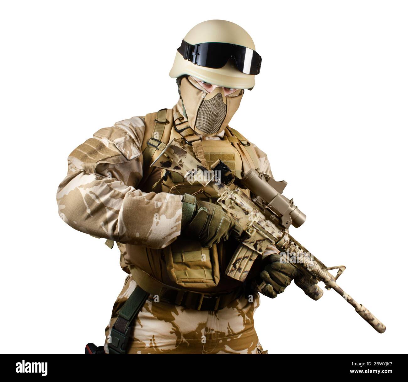 Foto isolata di un soldato del deserto completamente attrezzato armato di fucile automatico su sfondo bianco. Foto Stock