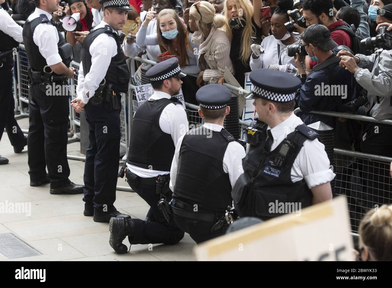 Londra, Gran Bretagna. 3 Giugno 2020. Due poliziotti si inginocchiano davanti ai manifestanti fuori da Downing Street a Londra, Gran Bretagna, il 3 giugno 2020. Migliaia di persone si sono riunite a Londra mercoledì per protestare per la morte di George Floyd, un uomo nero disarmato soffocato a morte da un ufficiale di polizia bianco nello stato del Minnesota, nel centro-occidentale. Credit: Ray Tang/Xinhua/Alamy Live News Foto Stock